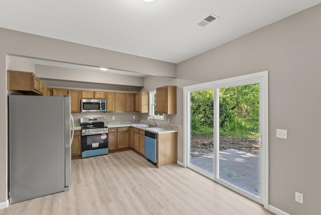 306 Young St, Georgetown, KY 40324 - kitchen with appliances with stainless steel finishes, a sink, light wood-style flooring, light countertops, and baseboards