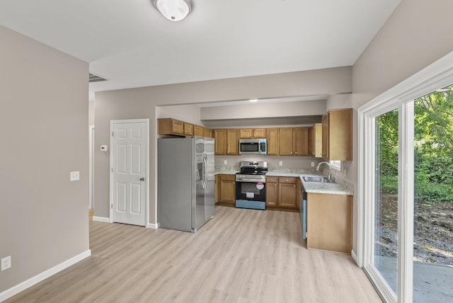 306 Young St, Georgetown, KY 40324 - kitchen with stainless steel appliances, a sink, light countertops, brown cabinets, and light wood-type flooring