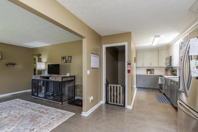 113 Jonathan Dr, Richmond, KY 40475 - kitchen featuring stainless steel appliances, wood finished floors, light countertops, a textured ceiling, and baseboards