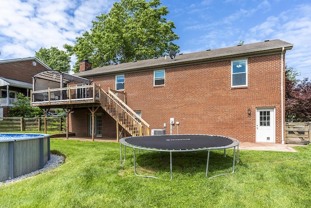 2018 E Ct, Richmond, KY 40475 - back of property featuring a trampoline, stairs, an outdoor pool, a deck, and brick siding