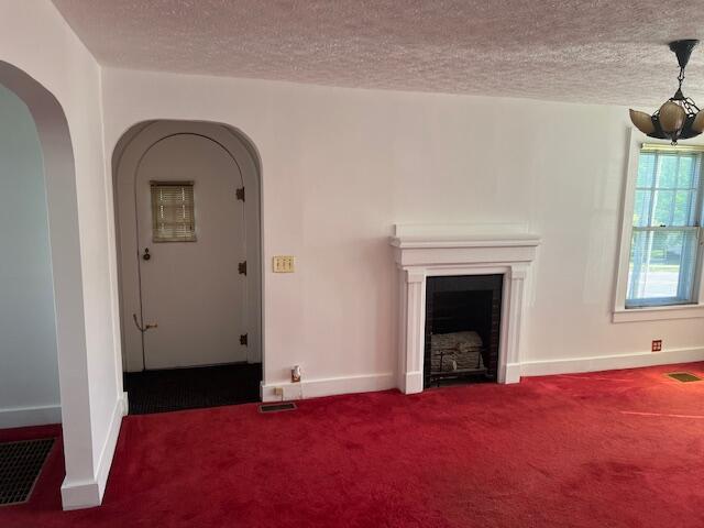 504 Burkesville St, Columbia, KY 42728 - carpeted living room with a textured ceiling, baseboards, a fireplace, and arched walkways