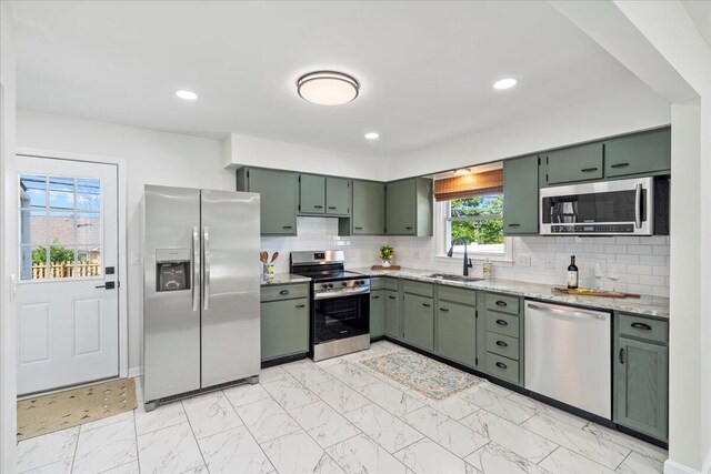 161 Toronto Rd, Lexington, KY 40515 - kitchen featuring stainless steel appliances, green cabinetry, a sink, light marble finish floors, and tasteful backsplash