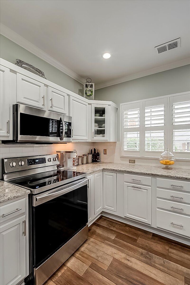 4172 Tradition Way, Lexington, KY 40509 - kitchen with appliances with stainless steel finishes, white cabinetry, crown molding, dark wood-style floors, and decorative backsplash