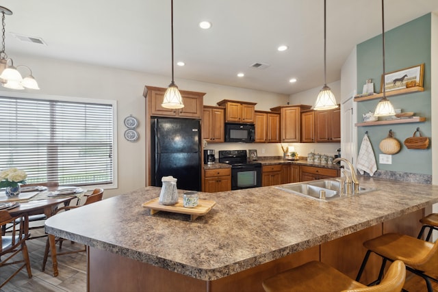 112 Woods Point Cir, Georgetown, KY 40324 - kitchen featuring black appliances, a sink, a peninsula, a breakfast bar, and brown cabinets