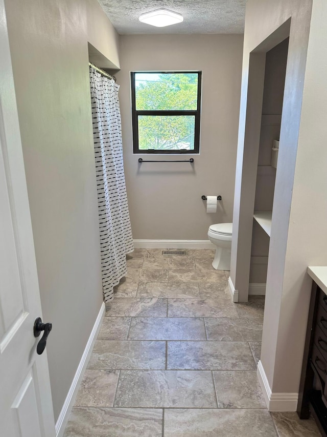 100 Cave Run Rd, Frankfort, KY 40601 - full bathroom with vanity, toilet, baseboards, stone tile floors, and a textured ceiling