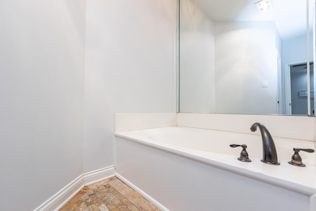 209 Juniper Dr, Nicholasville, KY 40356 - bathroom featuring stone finish flooring, a bath, and baseboards