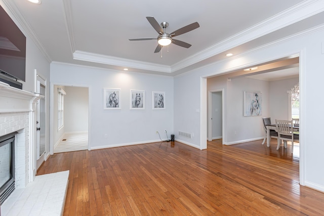 209 Juniper Dr, Nicholasville, KY 40356 - unfurnished living room featuring wood-type flooring, a ceiling fan, a tray ceiling, a brick fireplace, and baseboards