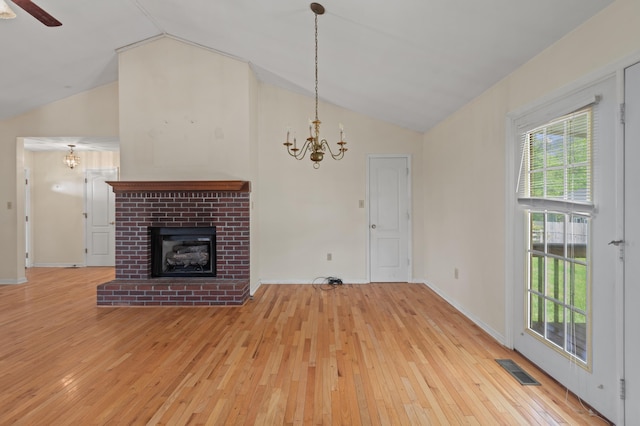 113 Alta Dr, Lawrenceburg, KY 40342 - unfurnished living room featuring vaulted ceiling, a chandelier, hardwood / wood-style floors, a brick fireplace, and a ceiling fan