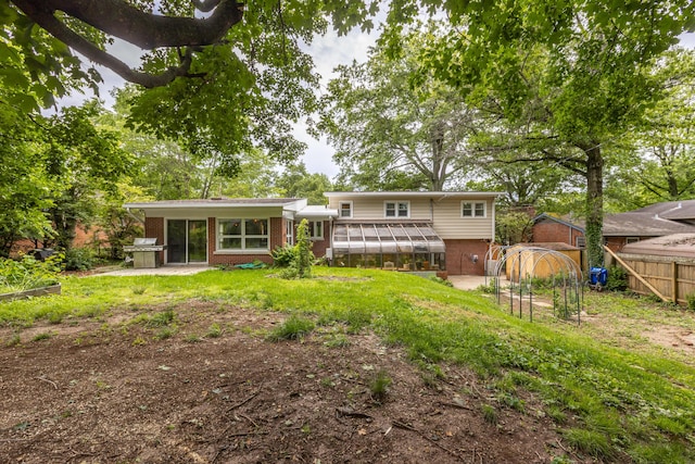 339 Greenbriar Rd, Lexington, KY 40503 - back of property with brick siding, a sunroom, a patio, and a greenhouse