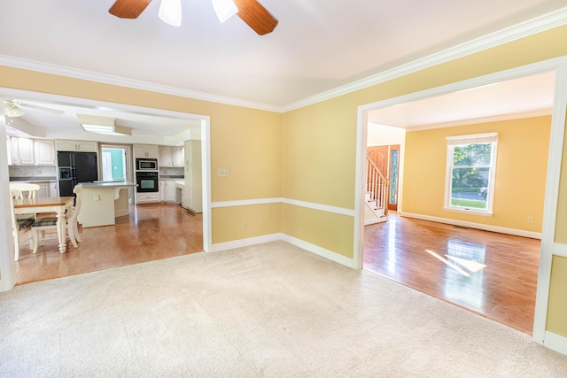 6011 Canonero Way, Versailles, KY 40383 - unfurnished living room with ceiling fan, stairs, light carpet, crown molding, and light wood finished floors