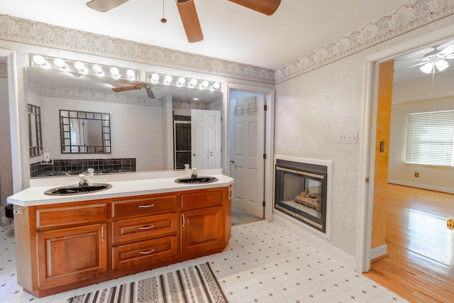6011 Canonero Way, Versailles, KY 40383 - bathroom with ceiling fan, a glass covered fireplace, double vanity, baseboards, and wood finished floors