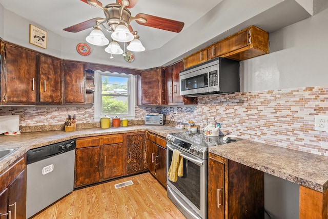 1023 Chickasaw Trl, Frankfort, KY 40601 - kitchen with appliances with stainless steel finishes, a ceiling fan, light wood-style floors, tasteful backsplash, and light countertops