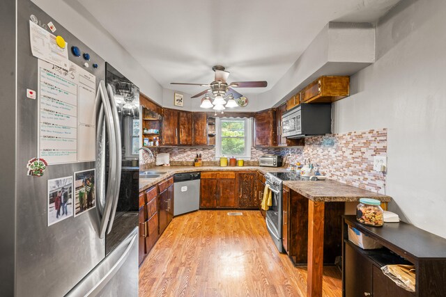 1023 Chickasaw Trl, Frankfort, KY 40601 - kitchen with appliances with stainless steel finishes, a ceiling fan, light wood-style floors, tasteful backsplash, and light countertops