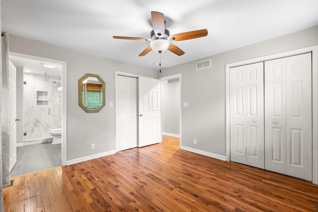 2849 Walnut Hill Rd, Lexington, KY 40515 - unfurnished bedroom with wood-type flooring, baseboards, multiple closets, ensuite bath, and ceiling fan
