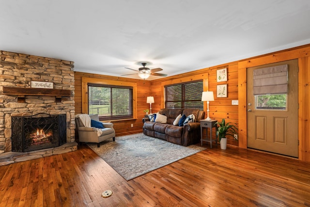 2849 Walnut Hill Rd, Lexington, KY 40515 - living room with hardwood / wood-style flooring, a ceiling fan, a stone fireplace, and wood walls