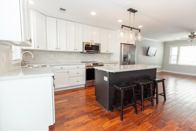 9412 Harrodsburg Rd, Wilmore, KY 40390 - kitchen featuring appliances with stainless steel finishes, a sink, dark wood finished floors, a breakfast bar area, and backsplash