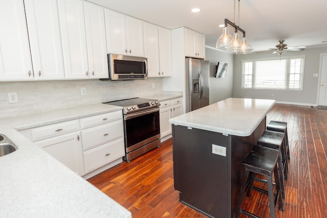 9412 Harrodsburg Rd, Wilmore, KY 40390 - kitchen with appliances with stainless steel finishes, a breakfast bar area, white cabinetry, and recessed lighting