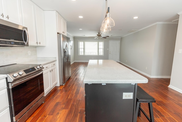 9412 Harrodsburg Rd, Wilmore, KY 40390 - kitchen with stainless steel appliances, ceiling fan, crown molding, a kitchen bar, and a center island
