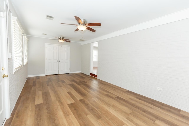 9412 Harrodsburg Rd, Wilmore, KY 40390 - unfurnished bedroom with brick wall, wood finished floors, a ceiling fan, a closet, and baseboards