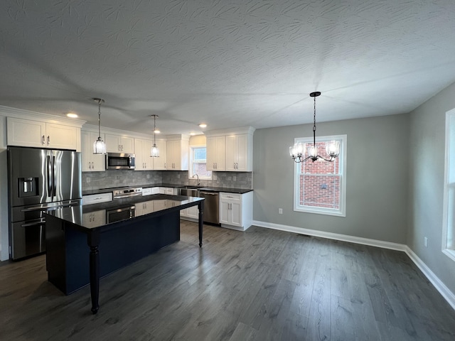309 Gallahadion Ct, Winchester, KY 40391 - kitchen featuring stainless steel appliances, dark countertops, baseboards, a chandelier, and a textured ceiling