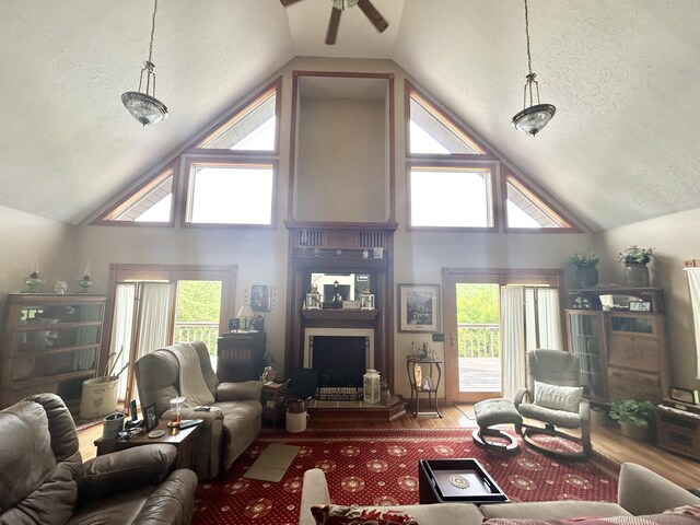 12430 E Ky-10, Quincy, KY 41166 - living room with ceiling fan, a textured ceiling, wood finished floors, high vaulted ceiling, and a fireplace