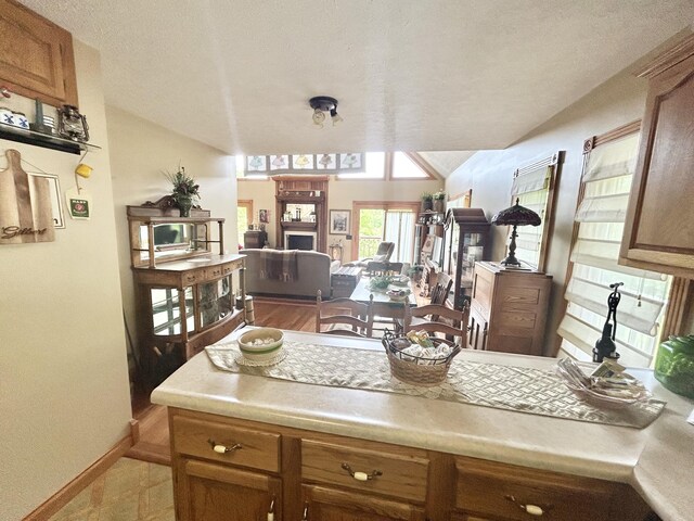 12430 E Ky-10, Quincy, KY 41166 - kitchen featuring vaulted ceiling, baseboards, light countertops, brown cabinetry, and open floor plan
