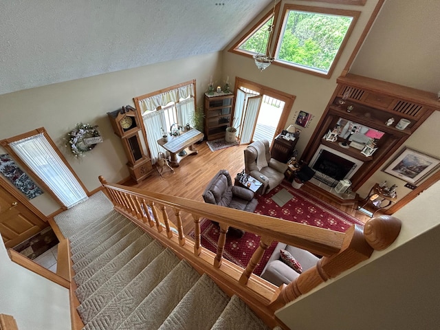 12430 E Ky-10, Quincy, KY 41166 - living area with a fireplace, a textured ceiling, high vaulted ceiling, and wood finished floors