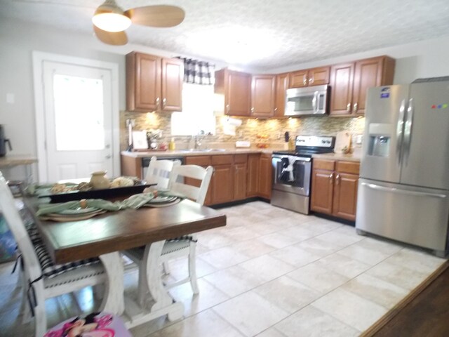 1129 Armstrong Mill Rd, Lexington, KY 40517 - kitchen with appliances with stainless steel finishes, decorative backsplash, light countertops, and a textured ceiling