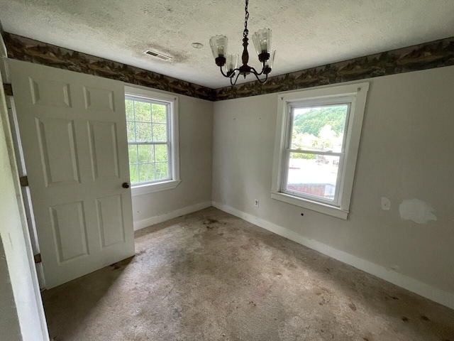 5069 Ky 11, Cannon, KY 40923 - empty room featuring a chandelier, a textured ceiling, and baseboards