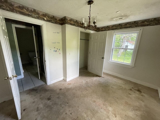 5069 Ky 11, Cannon, KY 40923 - unfurnished bedroom with a chandelier, a textured ceiling, a closet, and baseboards