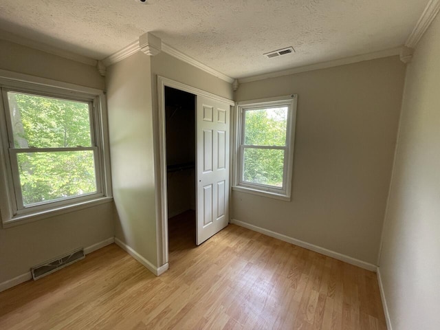 5069 Ky 11, Cannon, KY 40923 - unfurnished bedroom featuring ornamental molding, light wood-style flooring, baseboards, a closet, and a textured ceiling