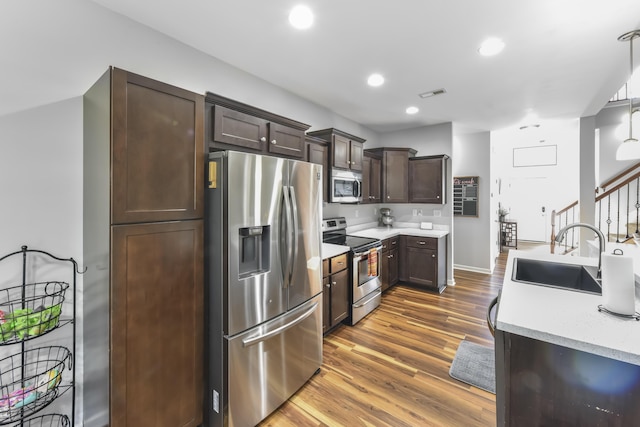 127 Schneider Blvd, Georgetown, KY 40324 - kitchen with appliances with stainless steel finishes, a sink, dark brown cabinets, dark wood-type flooring, and light countertops