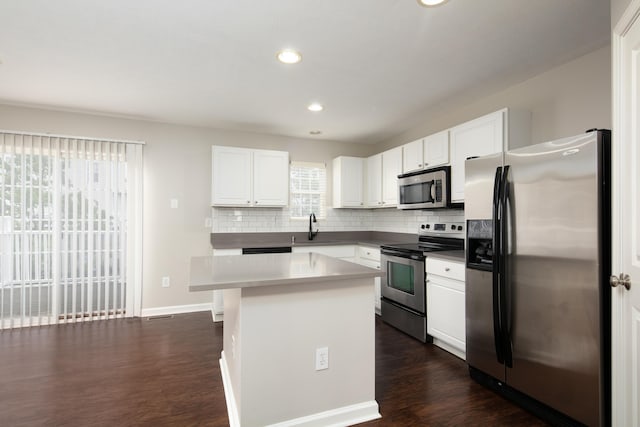 2429 Aristocracy Cir, Lexington, KY 40509 - kitchen with appliances with stainless steel finishes, a sink, decorative backsplash, white cabinets, and dark wood-type flooring