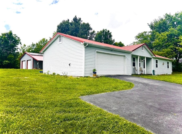 127 Circle St, London, KY 40744 - view of front of home with an attached garage, a metal roof, a front yard, and asphalt driveway