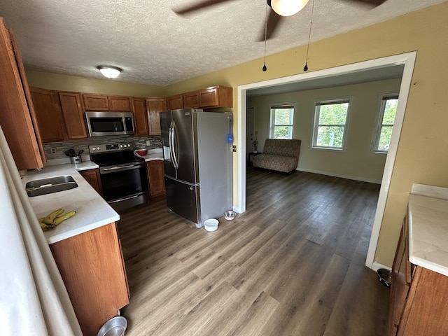 127 Circle St, London, KY 40744 - kitchen with appliances with stainless steel finishes, light countertops, brown cabinetry, ceiling fan, and a textured ceiling