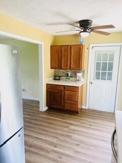 127 Circle St, London, KY 40744 - kitchen featuring freestanding refrigerator, ceiling fan, brown cabinetry, light countertops, and light wood-style flooring