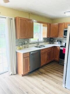 127 Circle St, London, KY 40744 - kitchen with appliances with stainless steel finishes, light wood finished floors, a sink, decorative backsplash, and light countertops