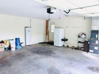 127 Circle St, London, KY 40744 - garage with water heater, a garage door opener, and fridge