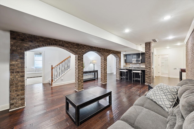 1821 Goodpaster Way, Lexington, KY 40505 - living area featuring arched walkways, baseboards, stairs, decorative columns, and dark wood-style flooring