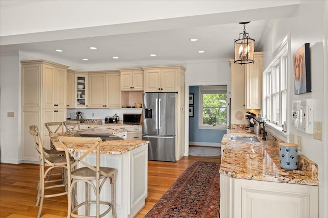 553 White Oak Rd, Stamping Ground, KY 40379 - kitchen featuring stainless steel refrigerator with ice dispenser, cream cabinetry, light wood-style floors, a sink, and light stone countertops