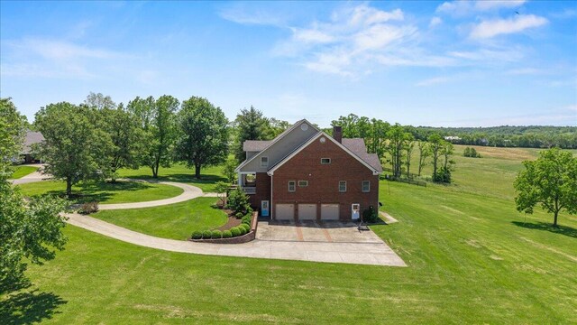 553 White Oak Rd, Stamping Ground, KY 40379 - view of side of property featuring a garage, concrete driveway, a chimney, and a lawn