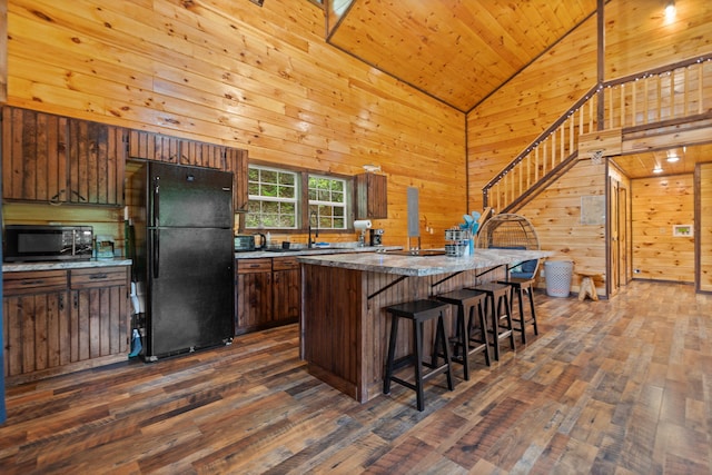 222 Muir Rd, Rogers, KY 41365 - kitchen featuring freestanding refrigerator, dark wood-type flooring, wood walls, a sink, and a kitchen bar