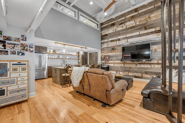 517 W Main St, Lexington, KY 40507 - living room featuring wood walls, a towering ceiling, light wood-type flooring, beamed ceiling, and bar