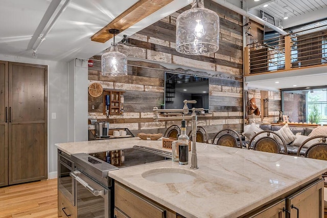 517 W Main St, Lexington, KY 40507 - kitchen featuring wood walls, light wood-style floors, beamed ceiling, stainless steel electric stove, and light stone counters
