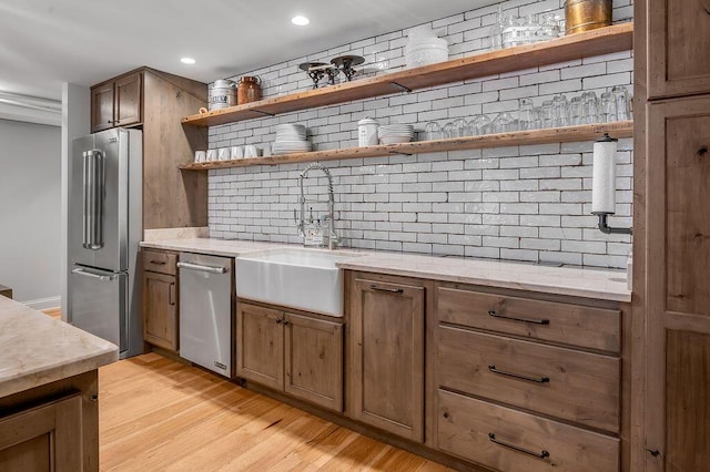 517 W Main St, Lexington, KY 40507 - kitchen featuring appliances with stainless steel finishes, a sink, tasteful backsplash, open shelves, and light wood-style flooring