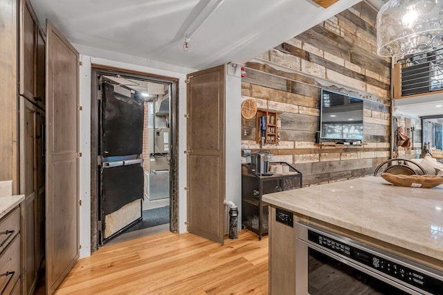 517 W Main St, Lexington, KY 40507 - kitchen with light wood-type flooring, wooden walls, light stone countertops, and oven