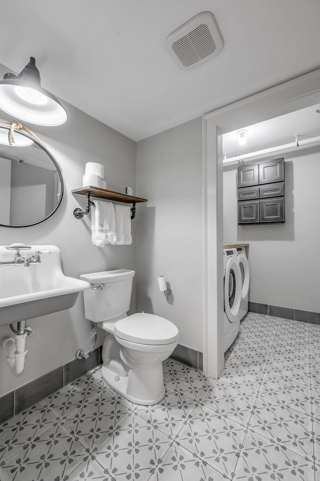 517 W Main St, Lexington, KY 40507 - bathroom with washing machine and dryer, toilet, and baseboards