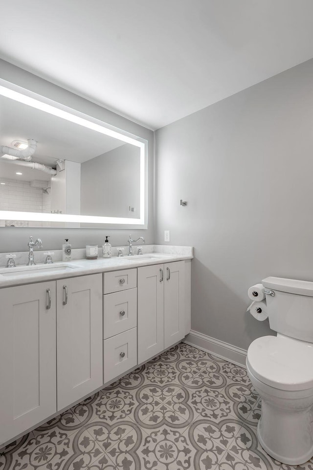 517 W Main St, Lexington, KY 40507 - full bathroom featuring baseboards, double vanity, and toilet