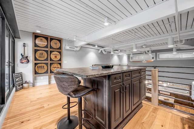 517 W Main St, Lexington, KY 40507 - kitchen featuring track lighting, light wood-style flooring, a kitchen bar, a kitchen island, and dark brown cabinets