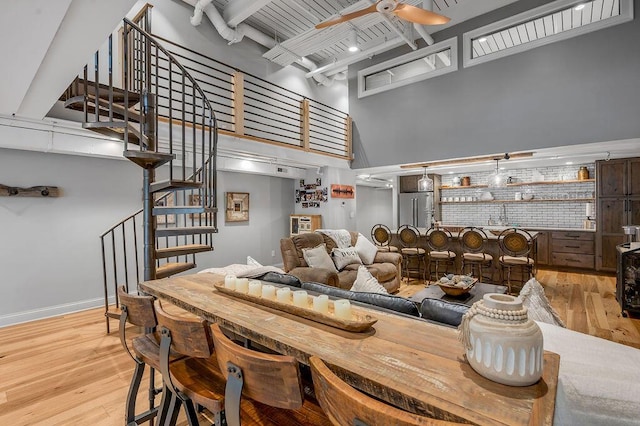517 W Main St, Lexington, KY 40507 - dining space featuring a towering ceiling, stairs, beam ceiling, wood finished floors, and a ceiling fan